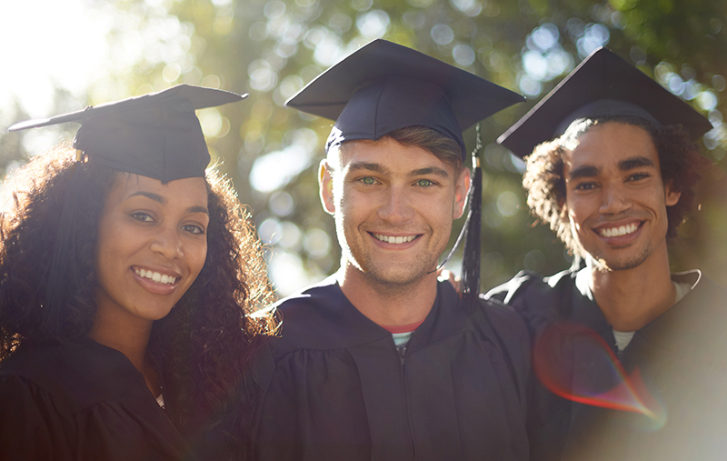 three graduates wearing robes and mortar boards